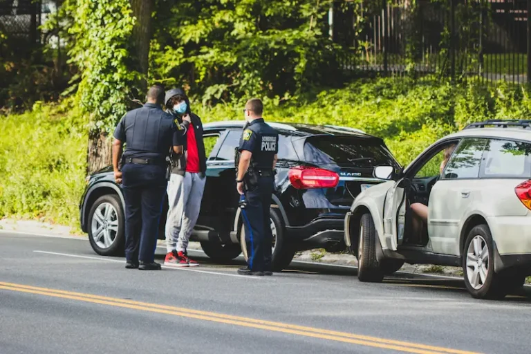Agente de policía junto a un auto después de un accidente de tráfico